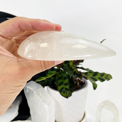 hand holding up Clear Quartz Tear Drop Shape showing side view of it