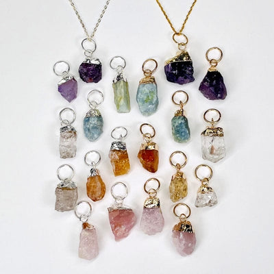 rough stone pendants in gold and silver displayed to show the differences in the pendant types 