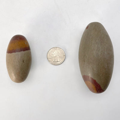 possible largest and smallest shiva lingam stones with quarter for size reference