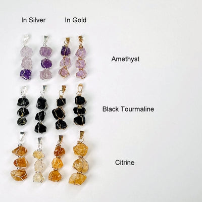 pendants in gold and silver next to their stone names. available in amethyst, black tourmaline and citrine