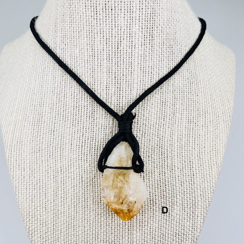 close up of the citrine pendant on a black cord necklace 
