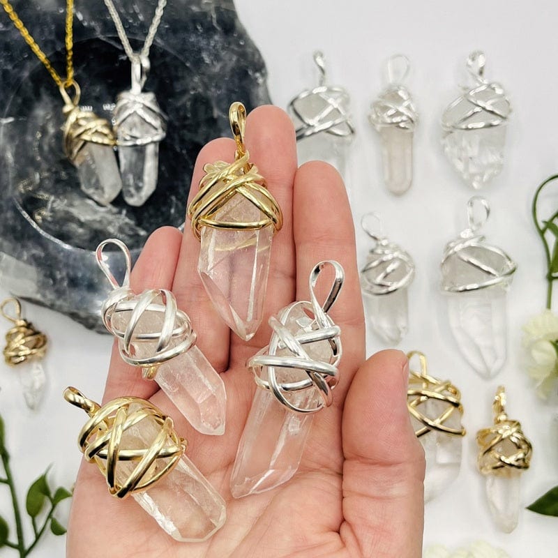 crystal quartz point pendants with thick wire wrapped cap and bail in hand for size reference 