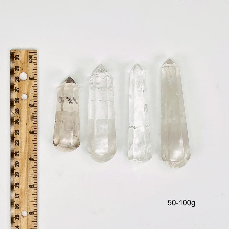 crystal quartz massage wands next to a ruler for size reference. showing possible sizes for 50-100g