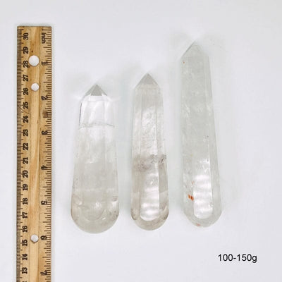 crystal quartz massage wands next to a ruler for size reference. showing possible sizes for 100-150g