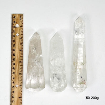 crystal quartz massage wands next to a ruler for size reference. showing possible sizes for 150-200g