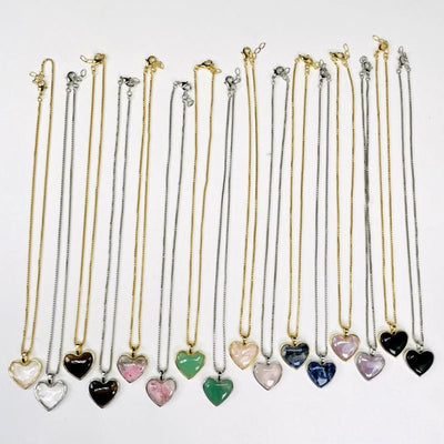 gold and silver heart shaped necklaces displayed to show the differences in the gemstones