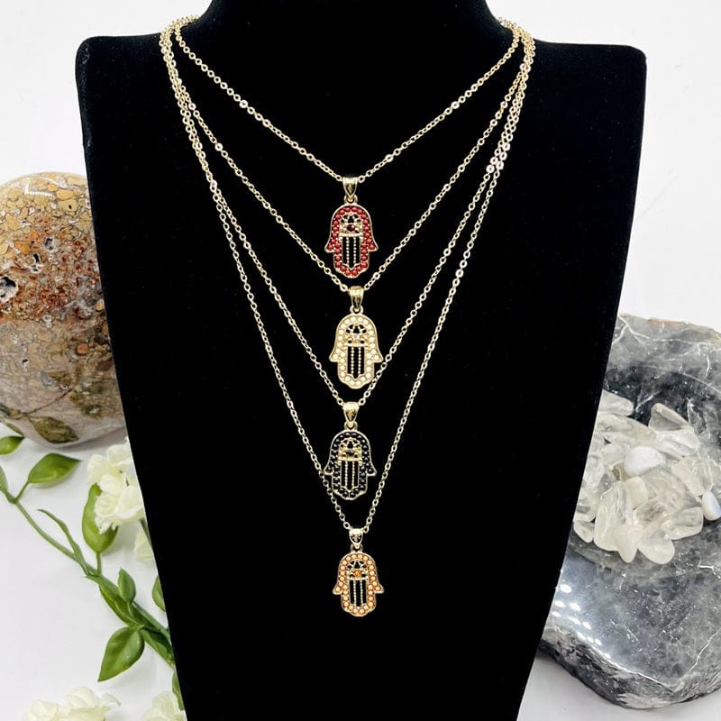 multiple hamsa hand necklaces displayed to show the differences in the color accents 