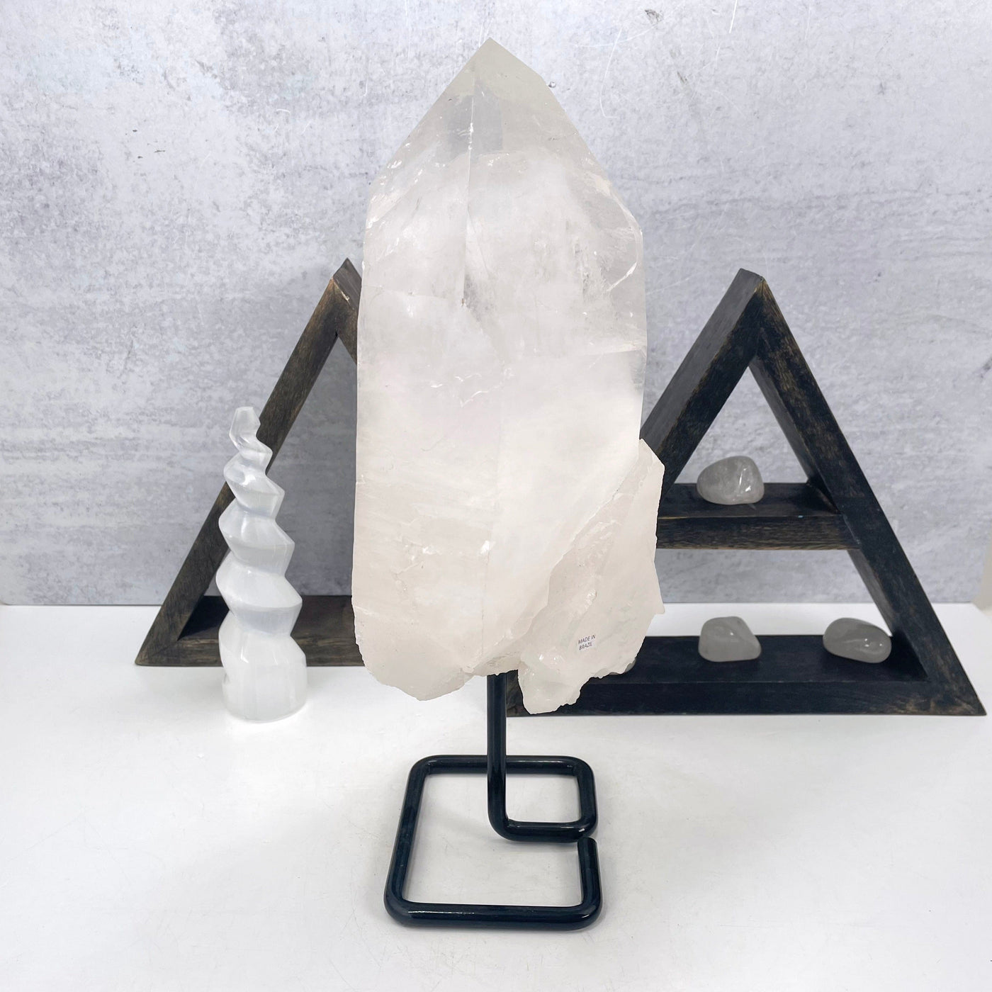 crystal quartz semi-polished point on metal stand on display