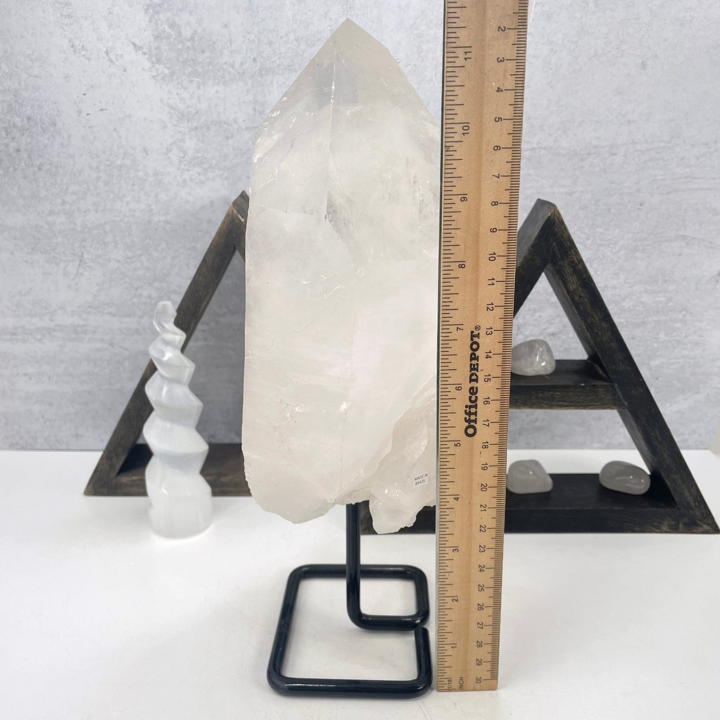 crystal quartz semi-polished point on metal stand with ruler for size reference