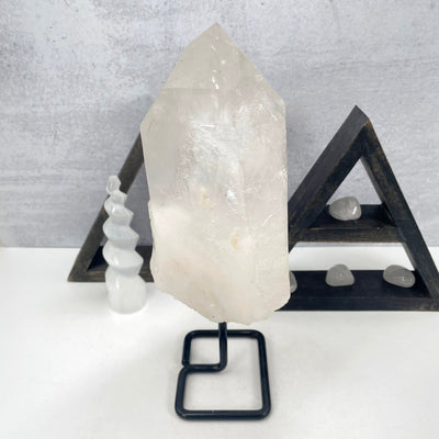 back view of crystal quartz semi-polished point on metal stand
