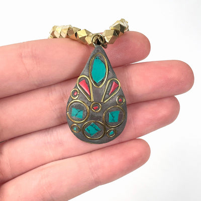 close up of middle tier pendant in hand for size reference and details