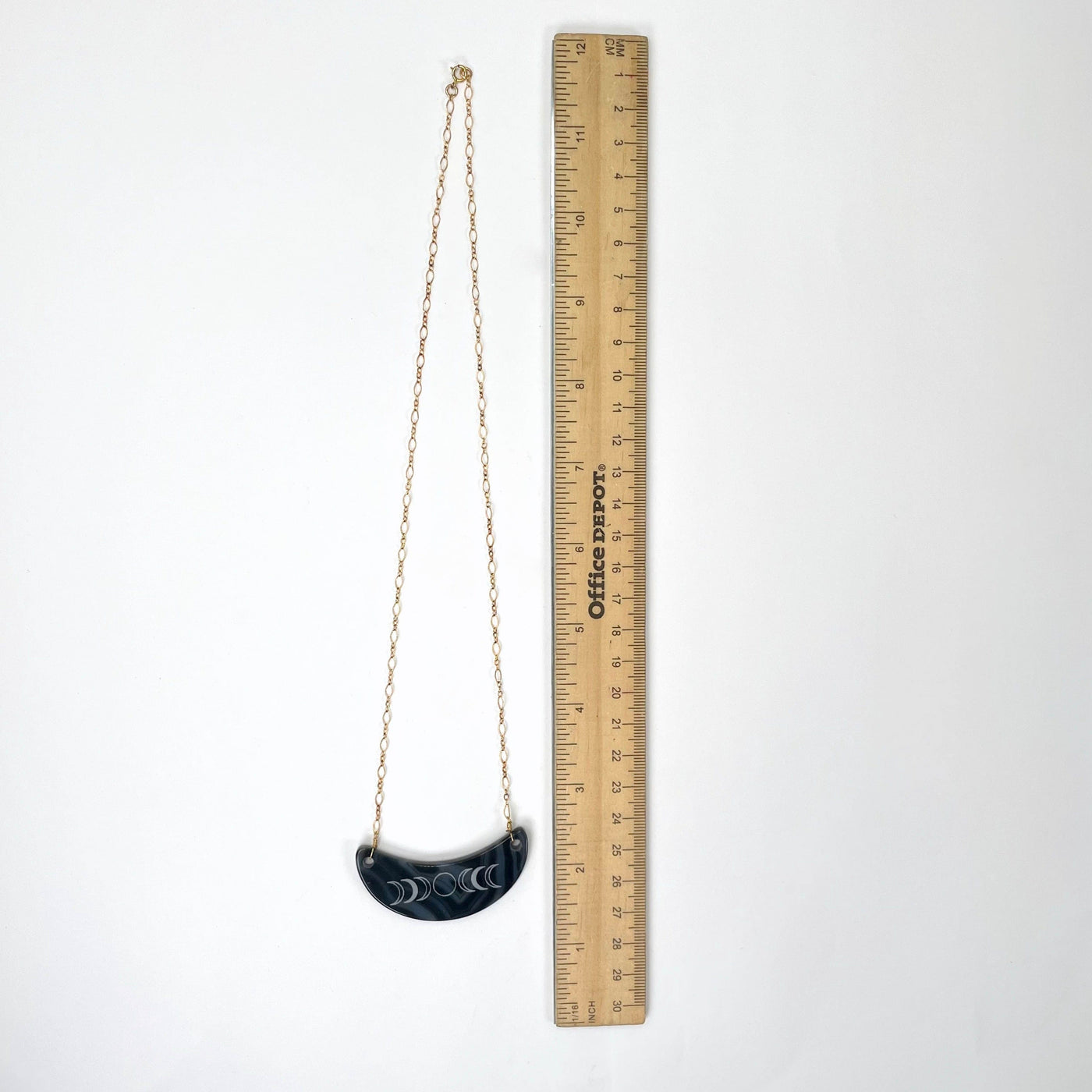 full length of dark blue agate crescent pendant necklace with moon phase with ruler for size reference