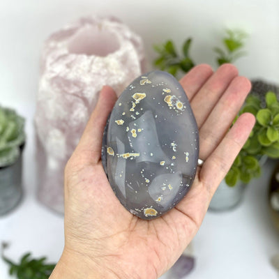 The backside of the polished agate geode box in a hand.