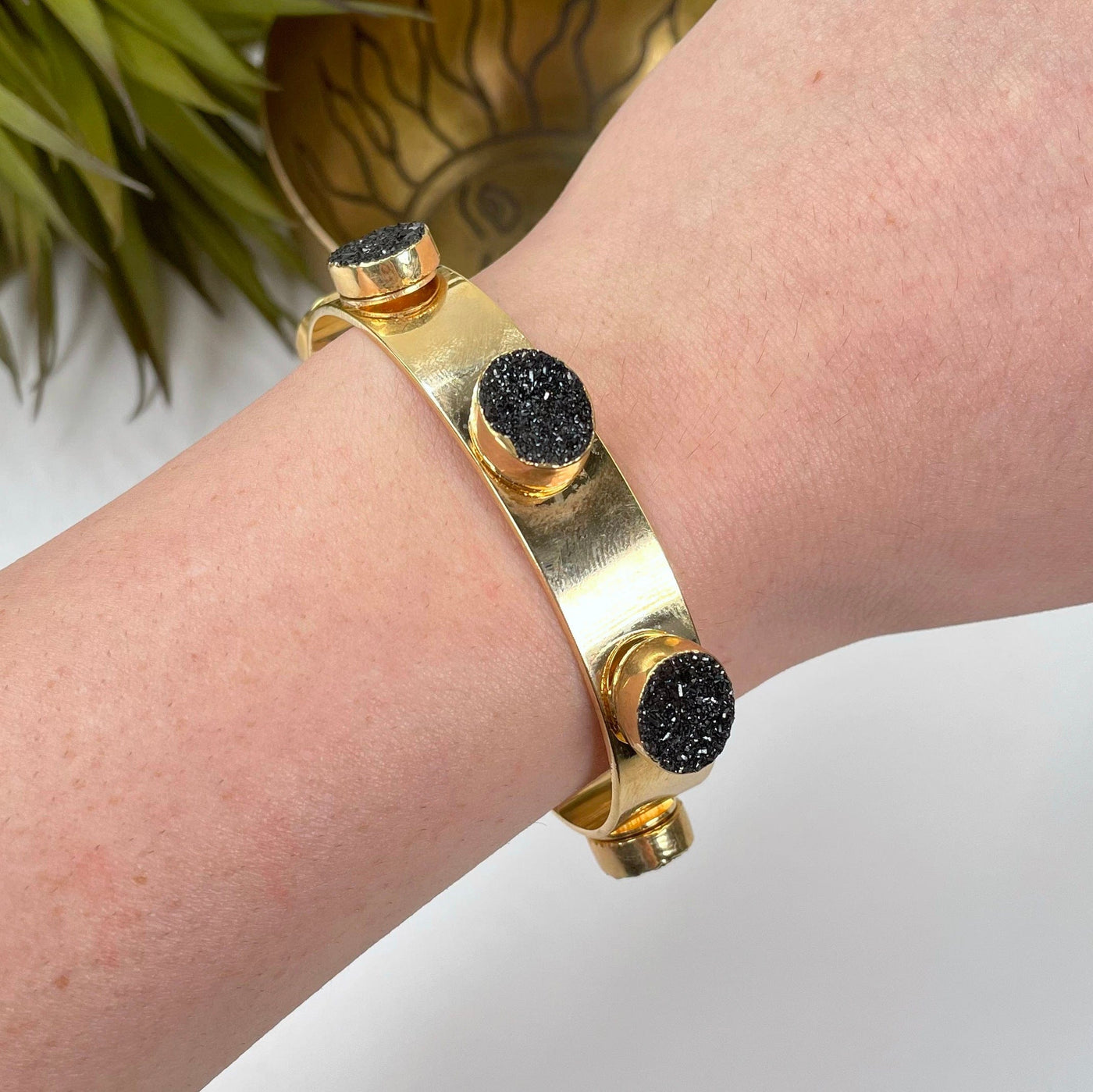 adjustable druzy cuff bracelet in electroplated gold on wrist for approximate size reference