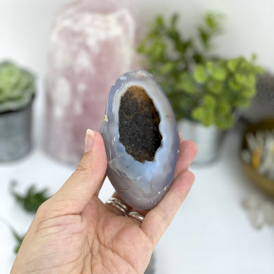 Half of the agate geode box in a hand displaying druzy.