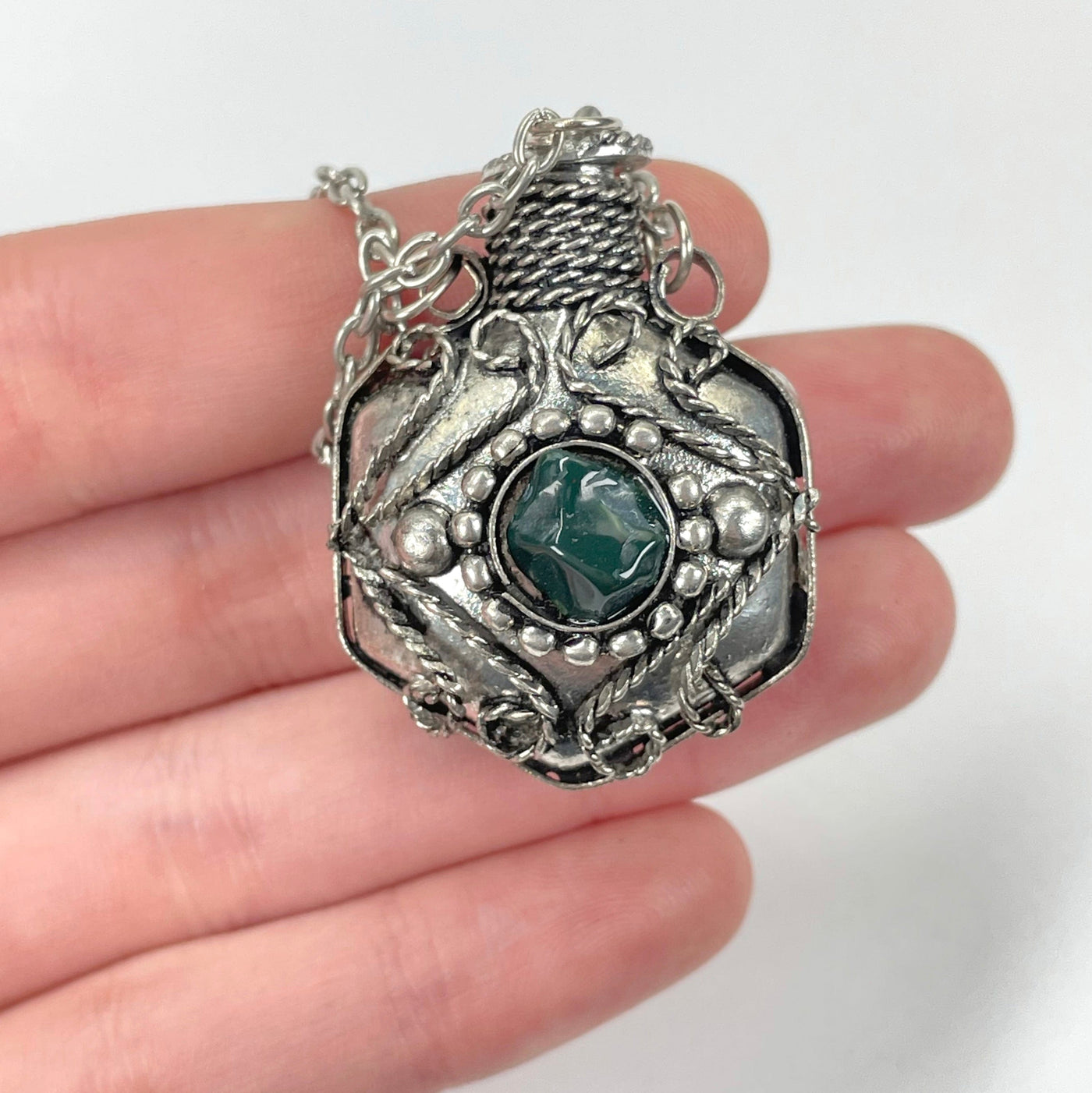close up of bloodstone bottle pendant necklace in hand for size reference and details