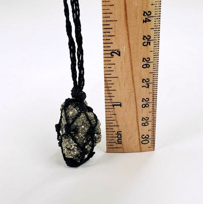 pyrite cluster next to a ruler for size reference 