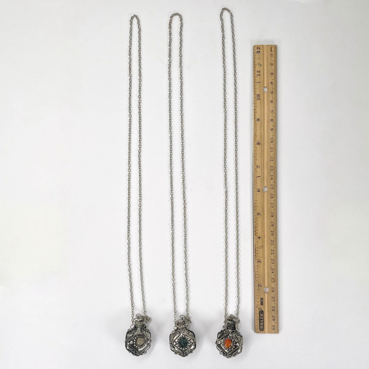 full length of bottle pendant necklaces with ruler for size reference 