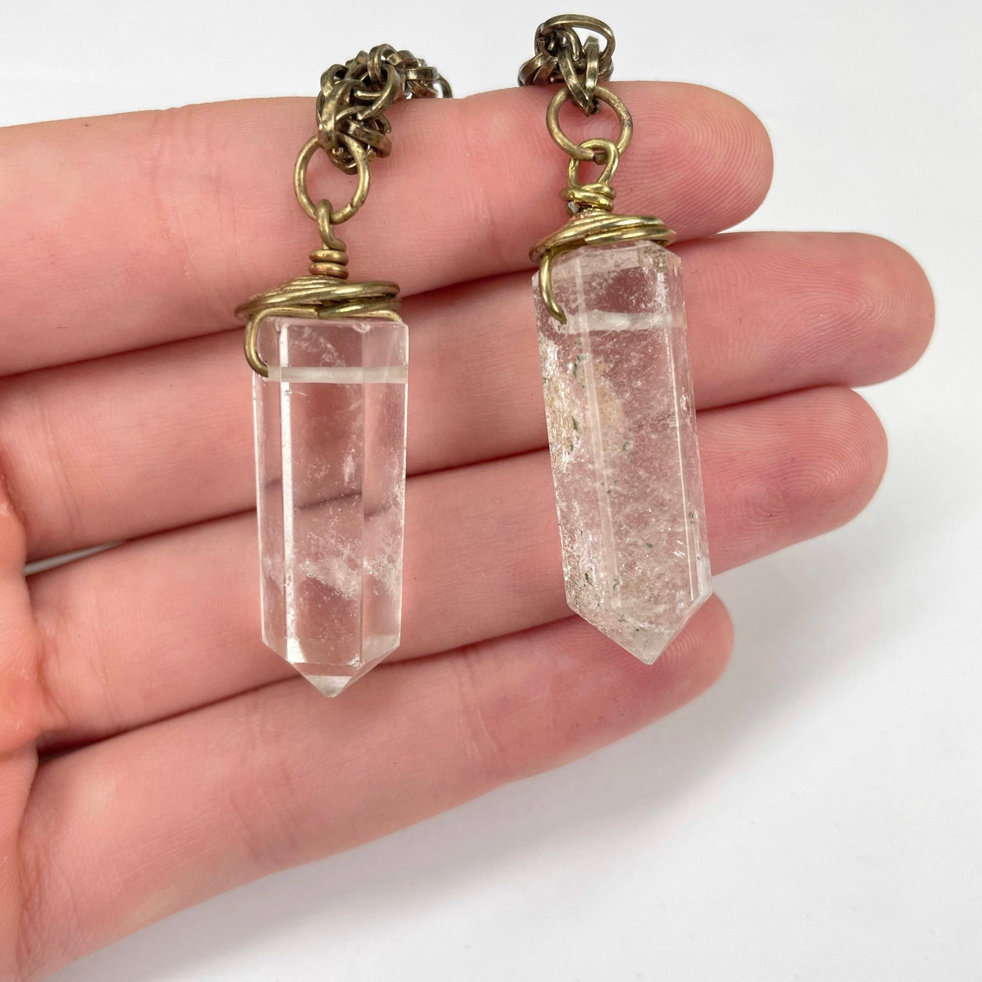 middle crystal quartz pendants in hand for size reference