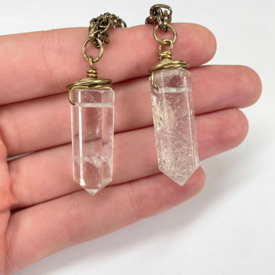 middle crystal quartz pendants in hand for size reference