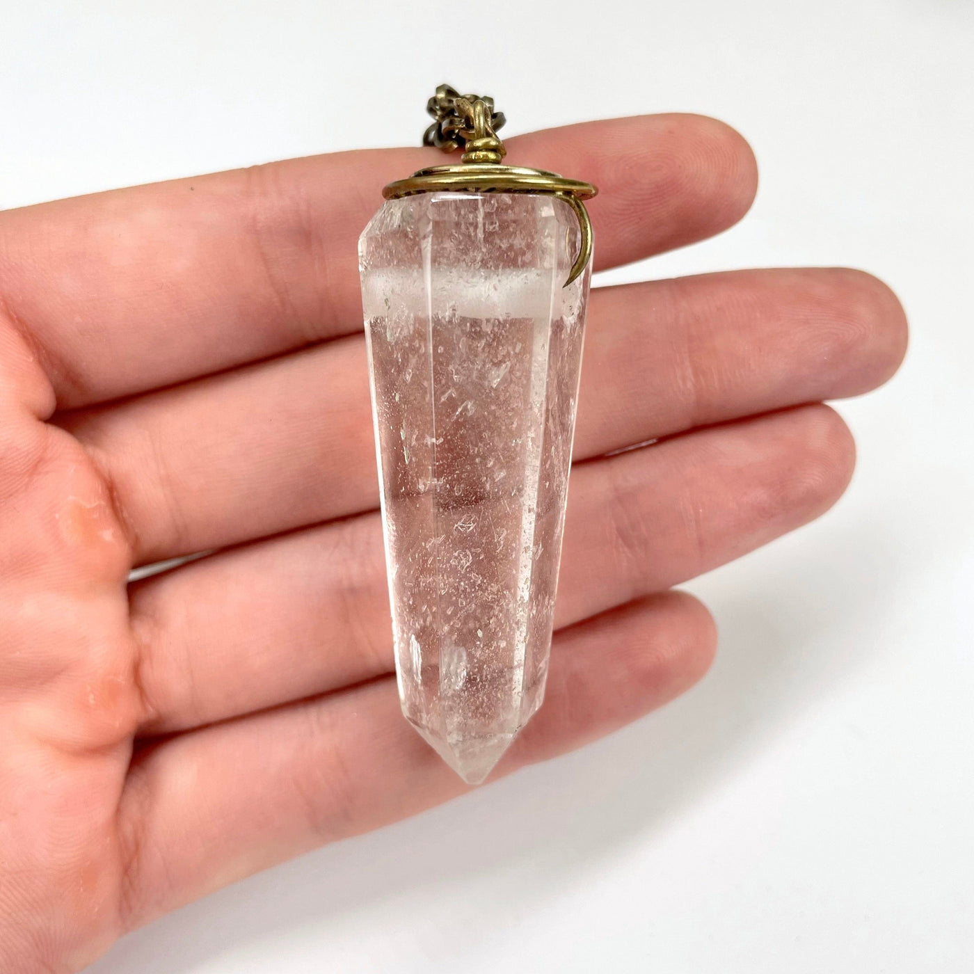 large center crystal quartz pendant in hand for size reference