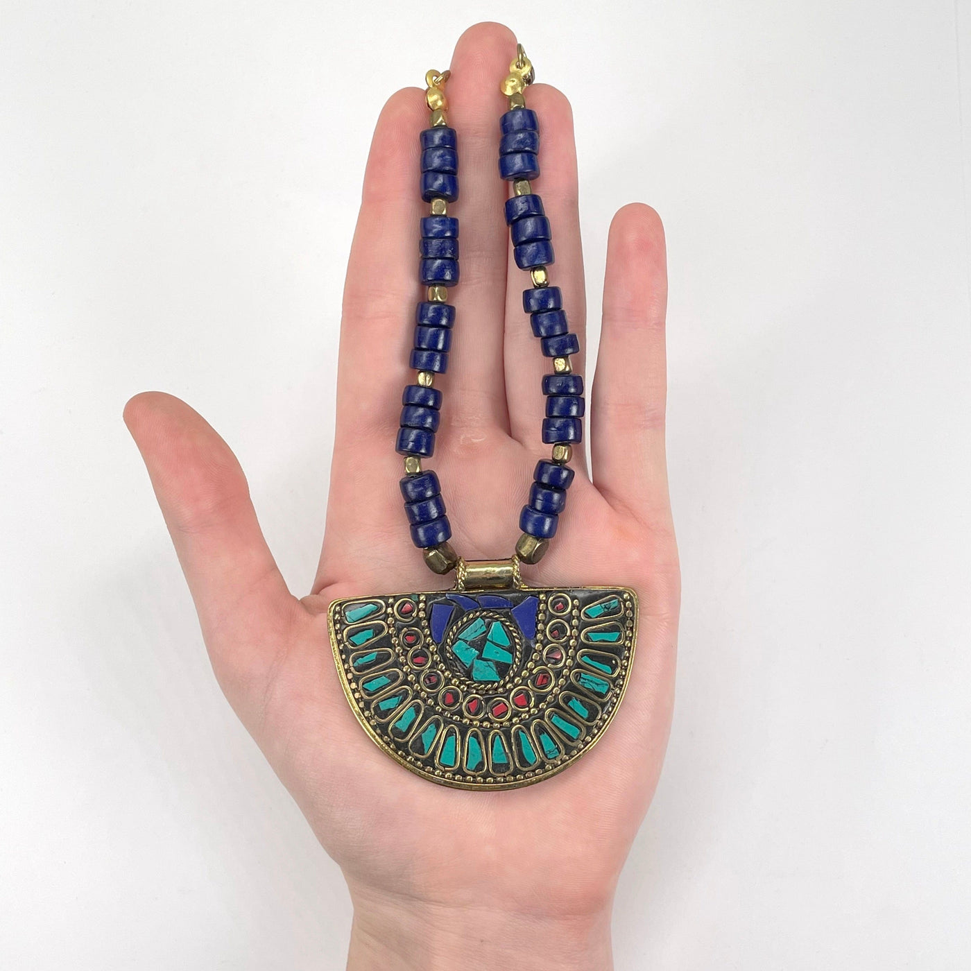 pendant and beaded portion of the necklace in hand for size reference
