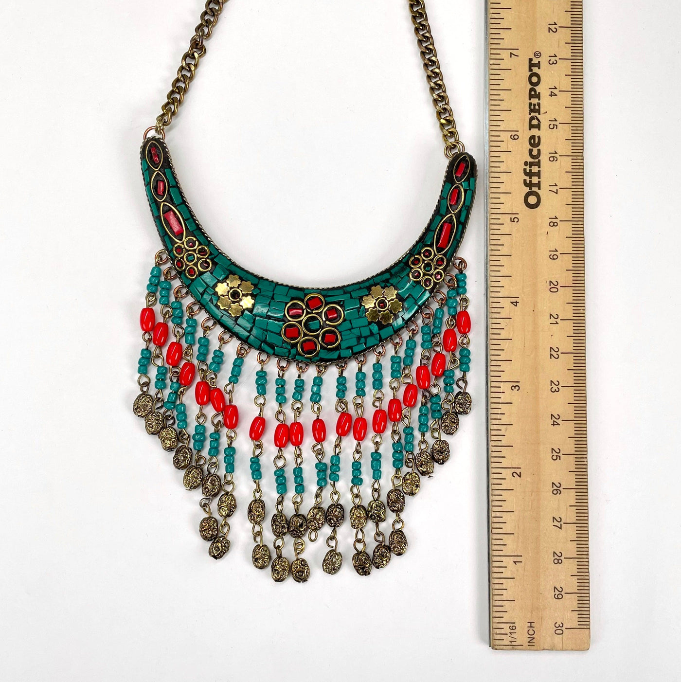 close up of tibetan style crescent pendant with beaded fringe with ruler for size reference