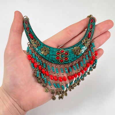tibetan style crescent pendant with beaded fringe in hand for size reference