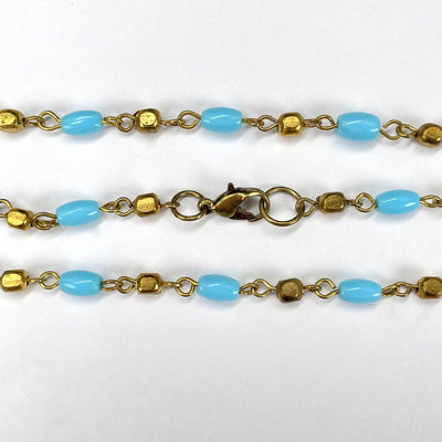 close up of necklace clasp and light blue and gold beads