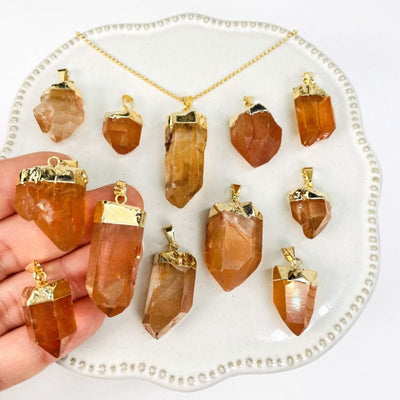 tangerine crystal quartz pendants in hand for size reference 