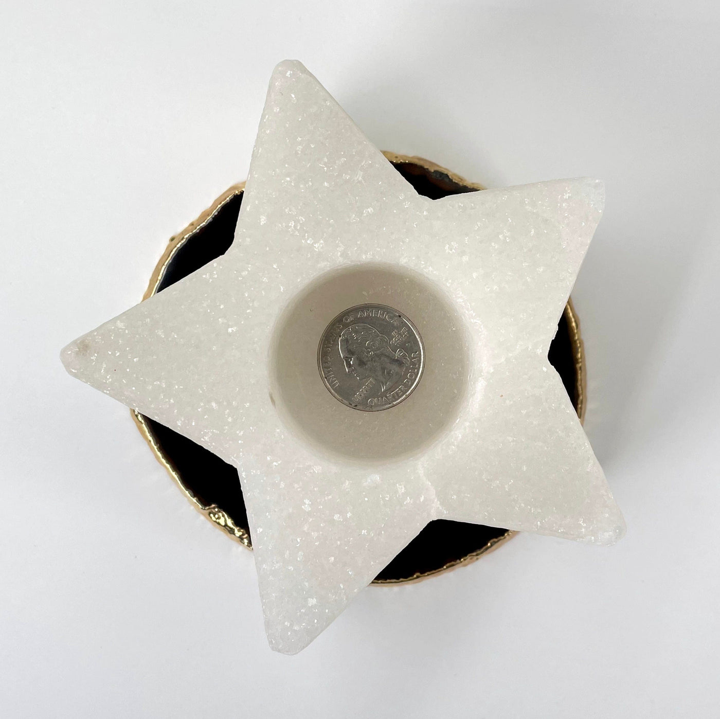 overhead view of one himalayan salt white star candle holder with quarter for size reference