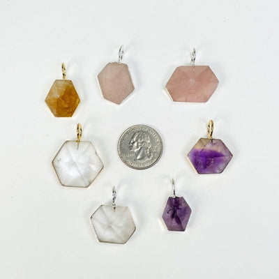 multiple pendants displayed next to a quarter for size reference 