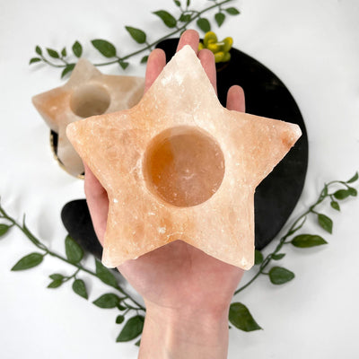 himalatan salt orange star candle holder in hand for size reference with another in background display