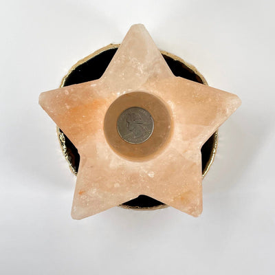 overhead view of himalayan salt orange star candle holder with quarter for size reference