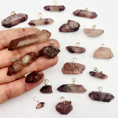 double terminated lithium quartz point pendants in hand for size reference 