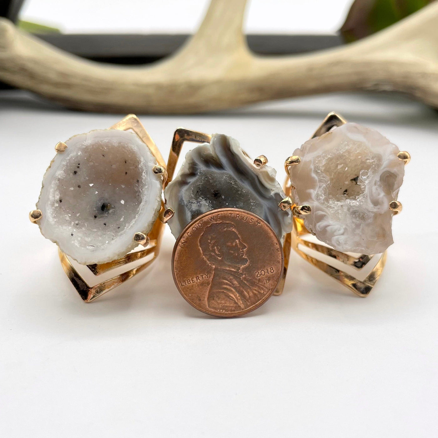 three geode half druzy rings with penny for size reference