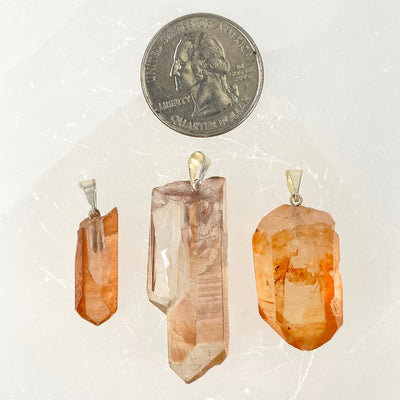 three tangerine rough point pendants with quarter for size reference