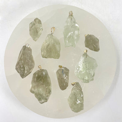 overhead view of many prasiolite rough pendants on display for possible variations 