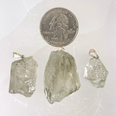 three prasiolite rough pendants with quarter for size reference