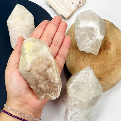 large dreamsicle lemurian quartz point in hand for size reference 