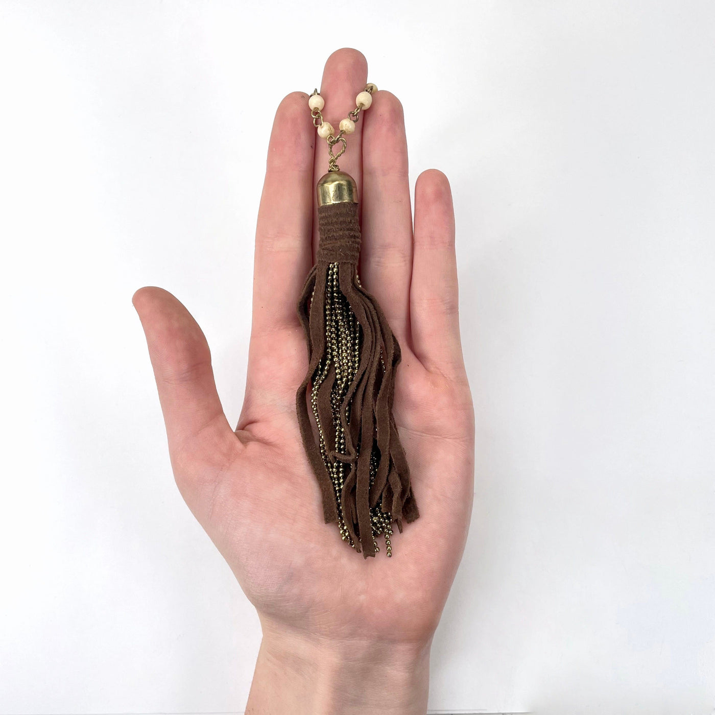 tassel pendant in hand for size reference