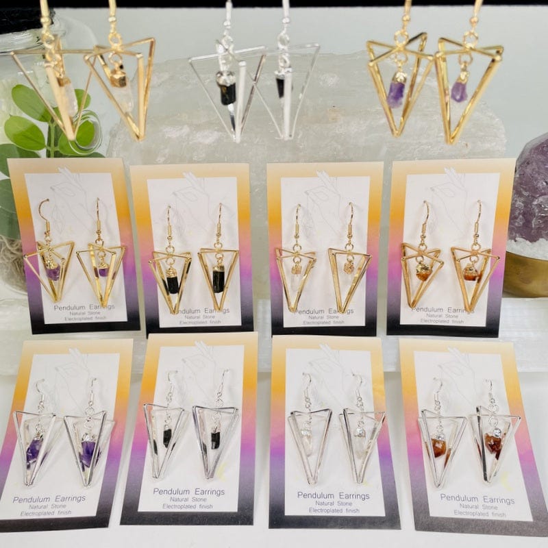 multiple pendulum earrings displayed to show the differences in the crystals available 