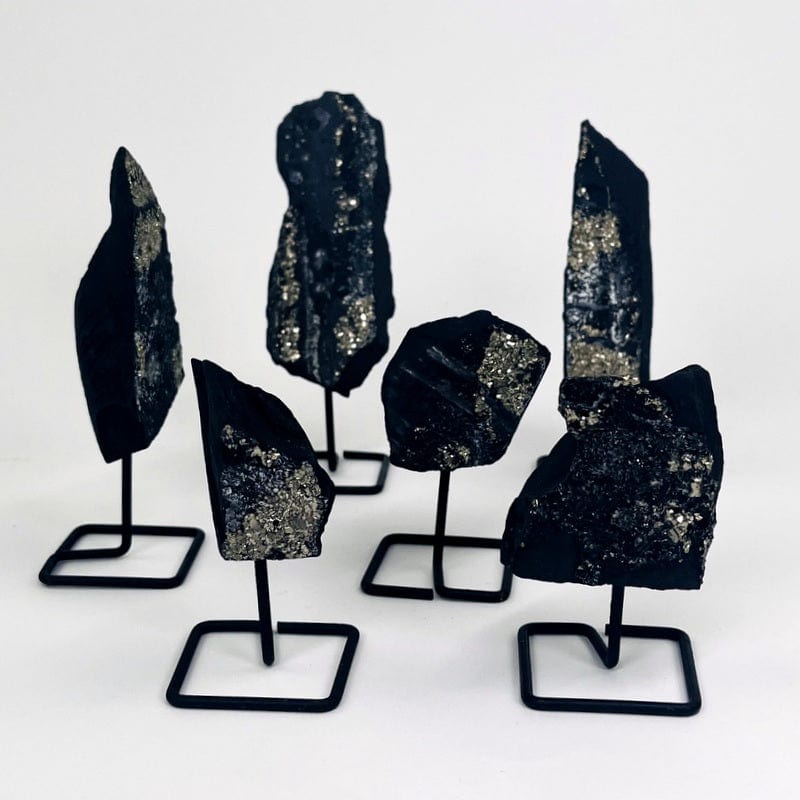 multiple pyrite on basalt metal stands displayed to show the different sizes