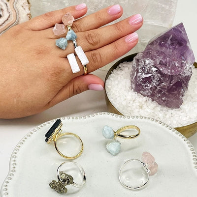 multiple crystal rings on hand for size reference 