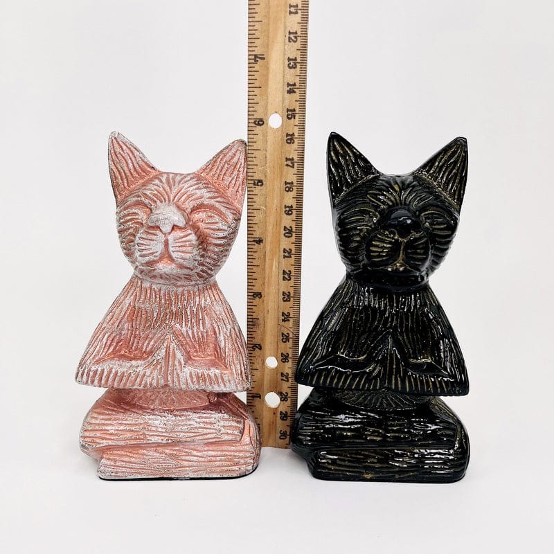 buddha cats next to a ruler for size reference 