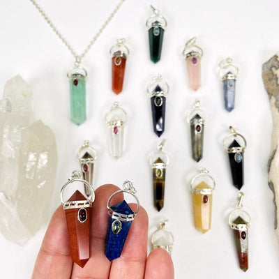 multiple double terminated pendants displayed to show the differences in the crystal types 