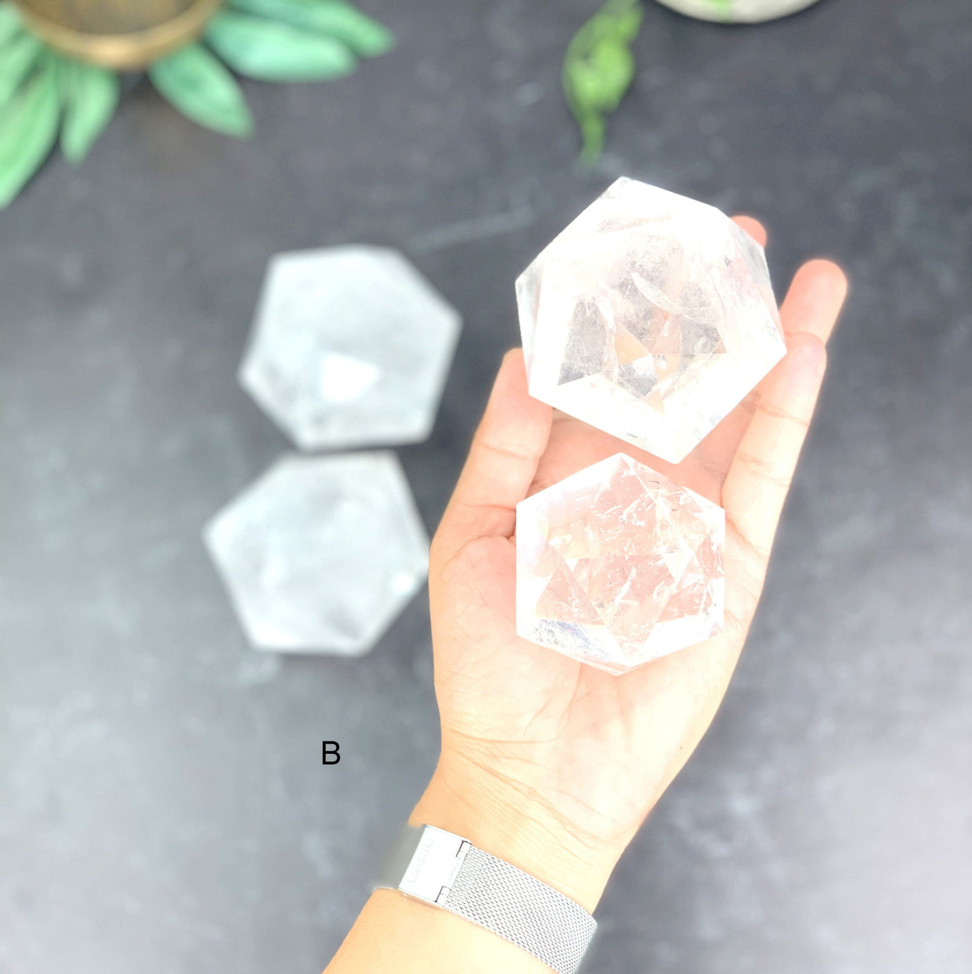 Hand holding option B a small and large Crystal Quartz  Icosahedron