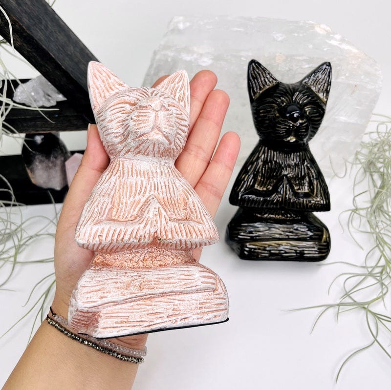 white buddha cat in hand for size reference 
