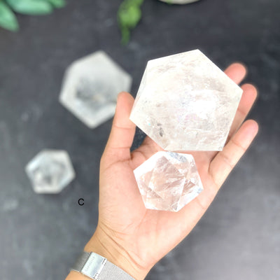 Hand holding option C a small and large Crystal Quartz Icosahedron