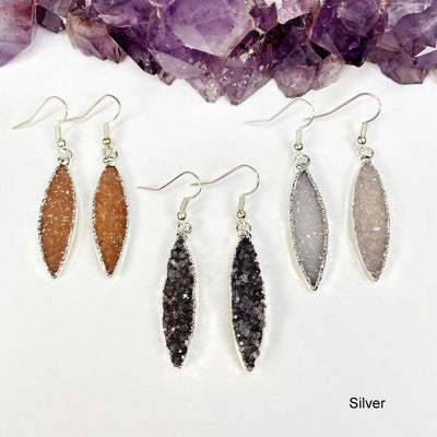 multiple silver earrings displayed to show the differences in the color shades 